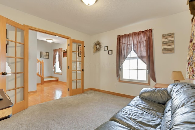 carpeted living room with a textured ceiling and french doors