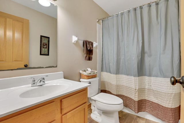 bathroom featuring vanity, hardwood / wood-style floors, walk in shower, and toilet