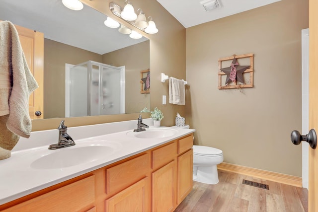 bathroom featuring an enclosed shower, vanity, hardwood / wood-style flooring, and toilet