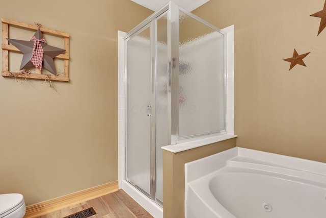 bathroom featuring hardwood / wood-style floors, toilet, and separate shower and tub