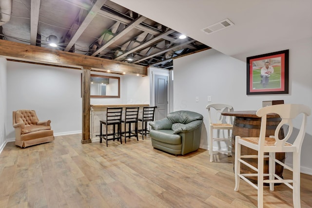 sitting room featuring bar area and light wood-type flooring