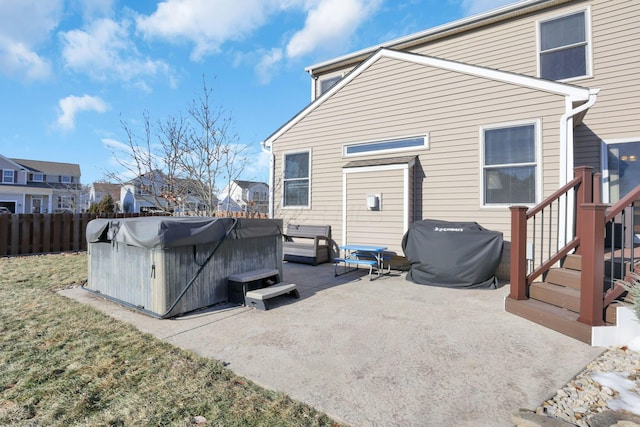 back of property featuring a hot tub and a patio