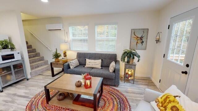 living room featuring light hardwood / wood-style floors and a wall unit AC