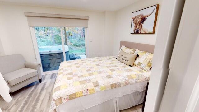 bedroom featuring access to exterior and light hardwood / wood-style flooring