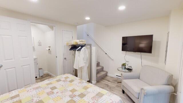 bedroom featuring light hardwood / wood-style floors and a baseboard heating unit