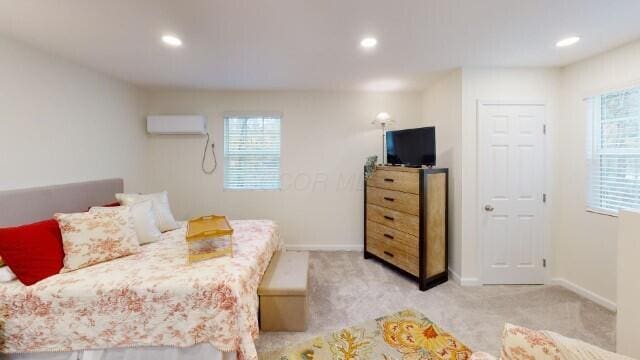 bedroom with light carpet and a wall unit AC