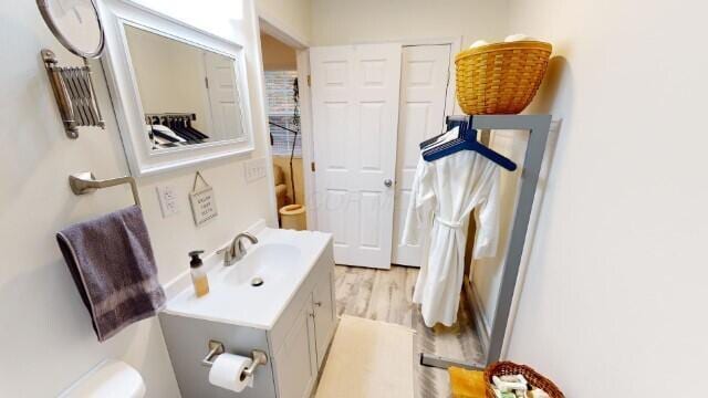 bathroom with vanity, toilet, and wood-type flooring