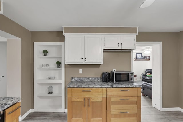 kitchen with white cabinetry and light hardwood / wood-style flooring