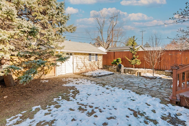 snowy yard with an outbuilding