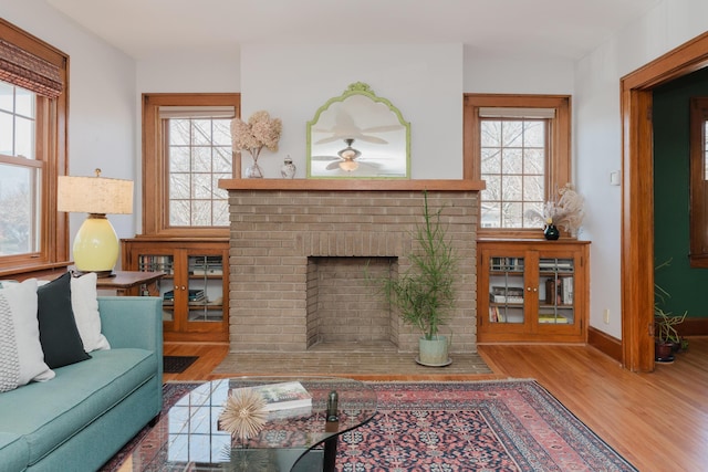 living room featuring a fireplace, a wealth of natural light, and light wood-type flooring