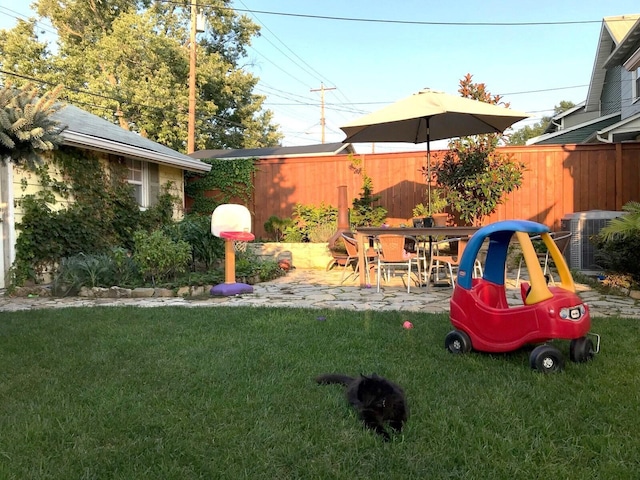 view of yard with central AC unit and a patio