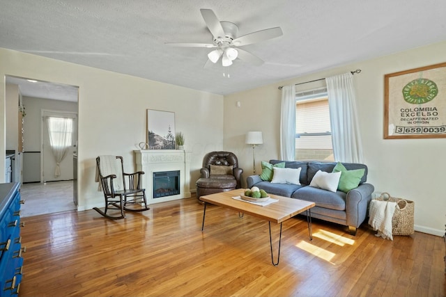 living room featuring hardwood / wood-style flooring, ceiling fan, and a healthy amount of sunlight