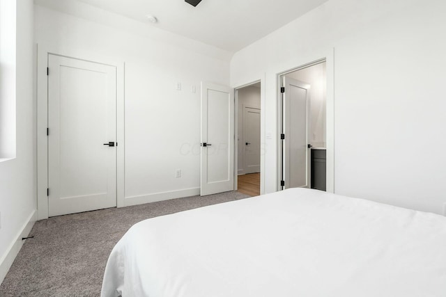 bedroom featuring light carpet and connected bathroom