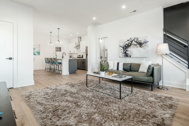 living room featuring sink and light wood-type flooring