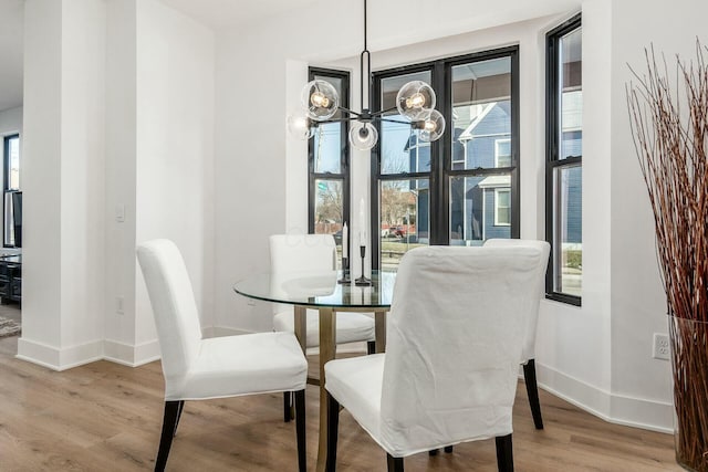 dining space with an inviting chandelier, light hardwood / wood-style flooring, and a wealth of natural light