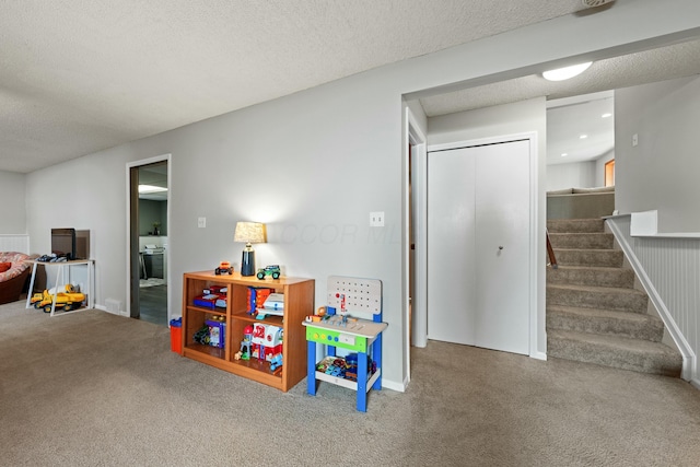 recreation room featuring carpet and a textured ceiling