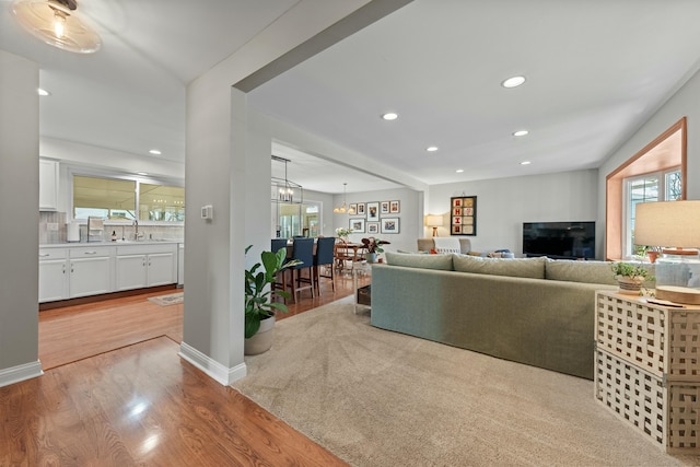 living area featuring a chandelier, light wood finished floors, plenty of natural light, and recessed lighting