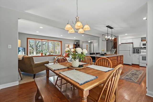 dining room with light wood finished floors, baseboards, a chandelier, and recessed lighting