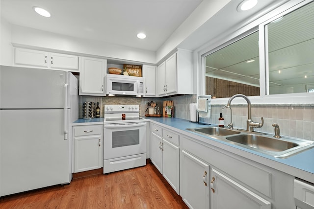 kitchen featuring white appliances, light countertops, light wood-type flooring, white cabinetry, and a sink