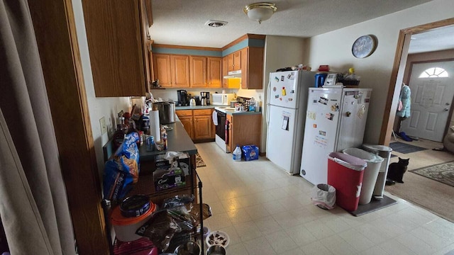 kitchen with a textured ceiling and white appliances