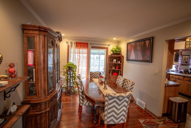 dining space featuring crown molding and dark wood-type flooring