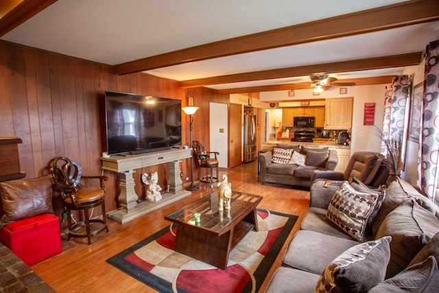 living room with beam ceiling, light hardwood / wood-style flooring, and wooden walls