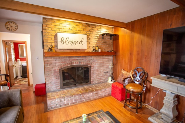 living room featuring wooden walls, hardwood / wood-style floors, and a fireplace