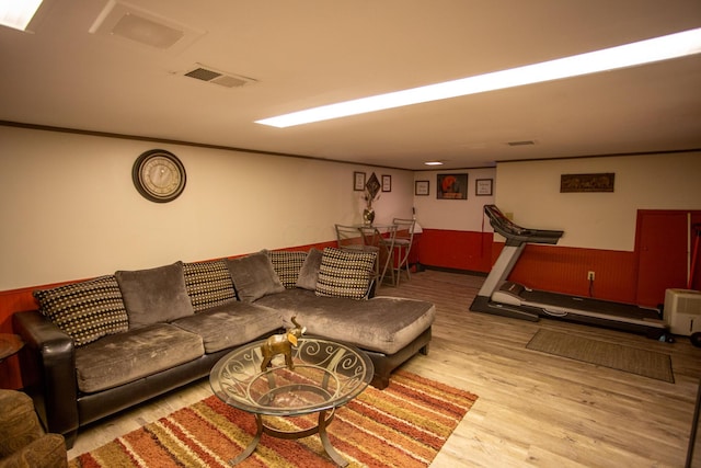 living room with crown molding and light hardwood / wood-style flooring