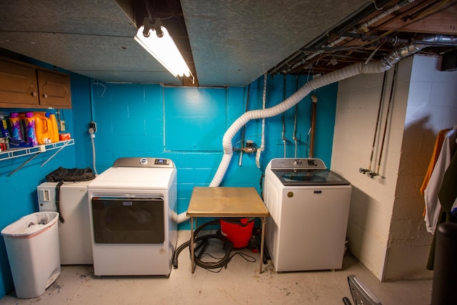 laundry room featuring separate washer and dryer and cabinets