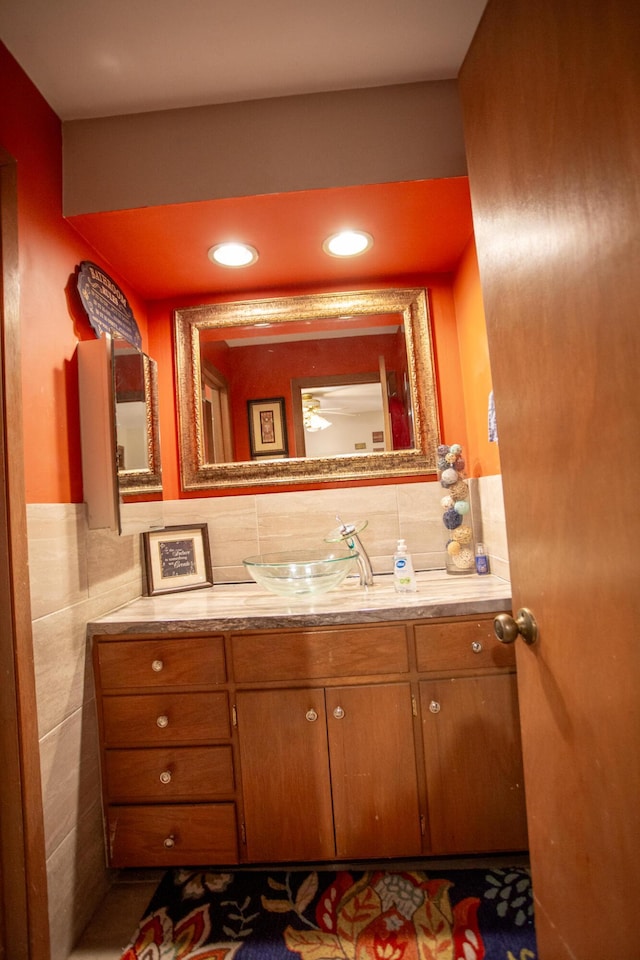 bathroom featuring vanity and tile walls