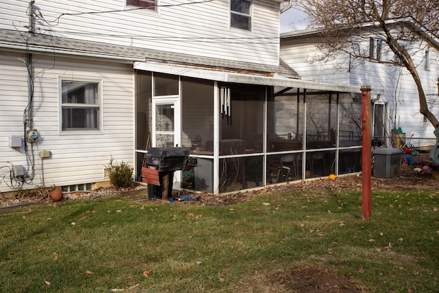 back of house with a sunroom and a lawn