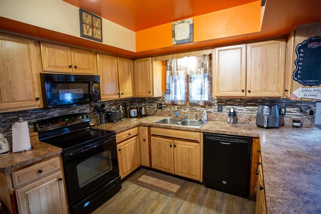 kitchen with tasteful backsplash, light hardwood / wood-style floors, sink, and black appliances