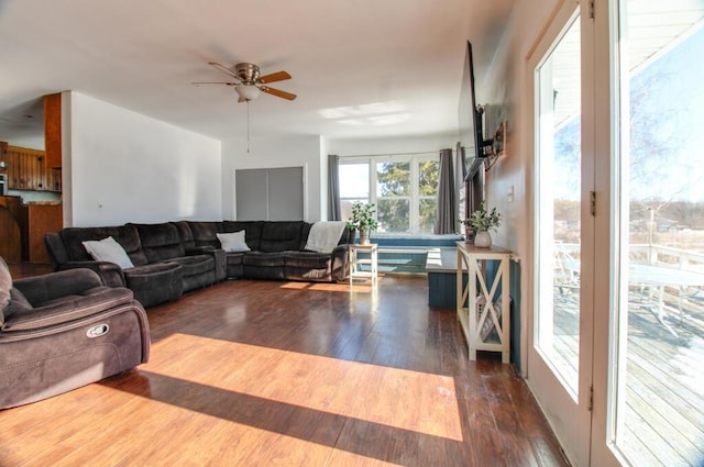 living room featuring dark wood-type flooring and ceiling fan