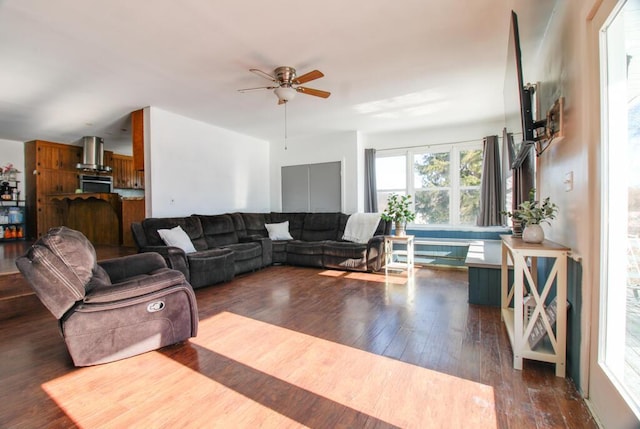 living room featuring dark wood-type flooring and ceiling fan