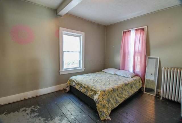 bedroom with beamed ceiling, dark hardwood / wood-style floors, and radiator heating unit