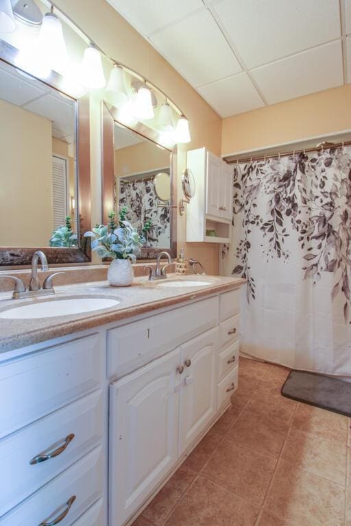 bathroom with vanity, a drop ceiling, and tile patterned floors