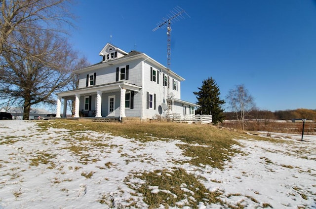 view of snowy exterior featuring a porch