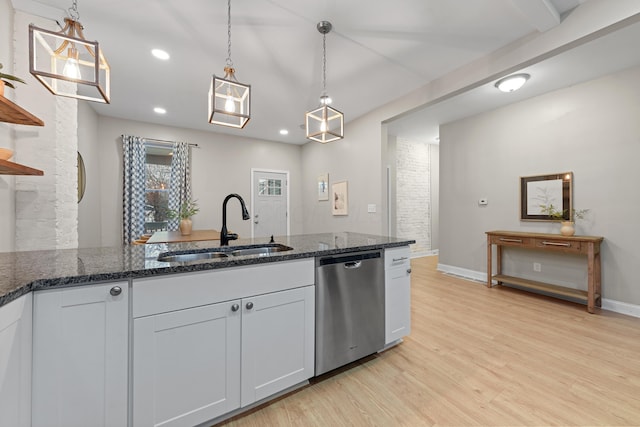 kitchen with pendant lighting, dark stone counters, dishwasher, and sink