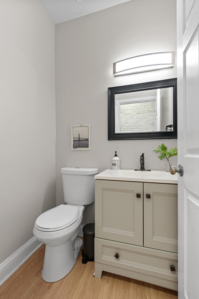 bathroom featuring vanity, toilet, and hardwood / wood-style floors