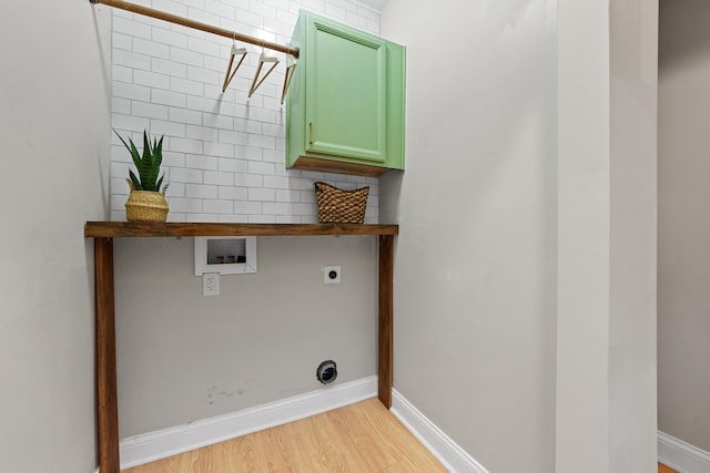 laundry area with electric dryer hookup, hookup for a washing machine, cabinets, and light wood-type flooring