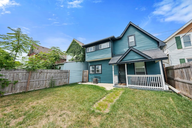 back of property with a yard and covered porch