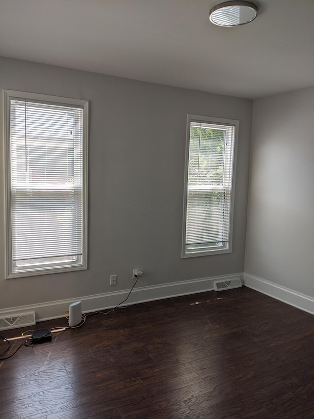 spare room featuring dark wood-type flooring