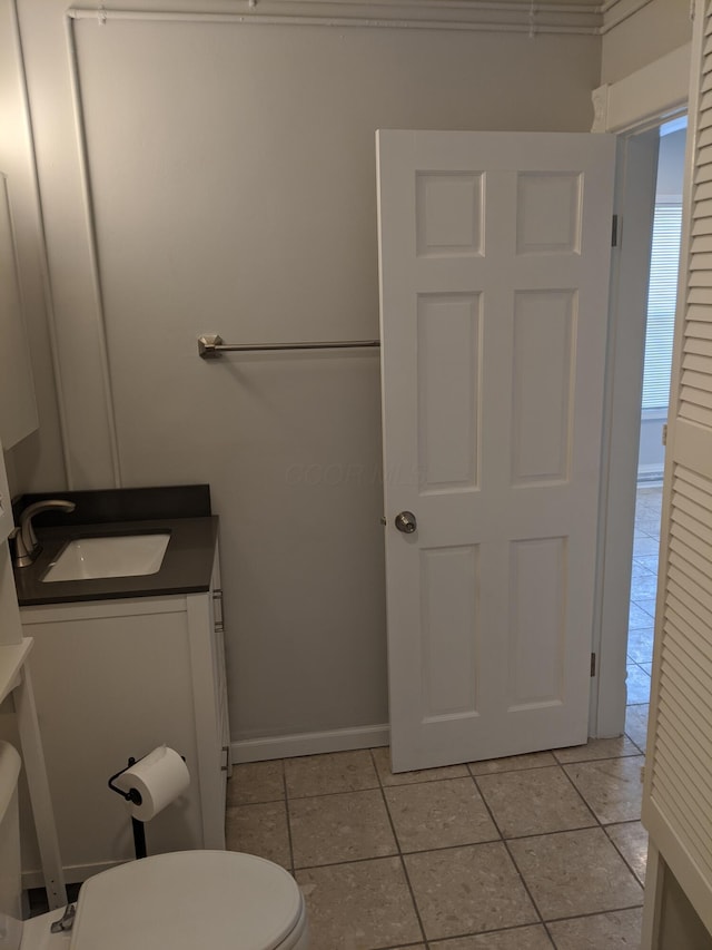 bathroom with tile patterned flooring, vanity, and toilet