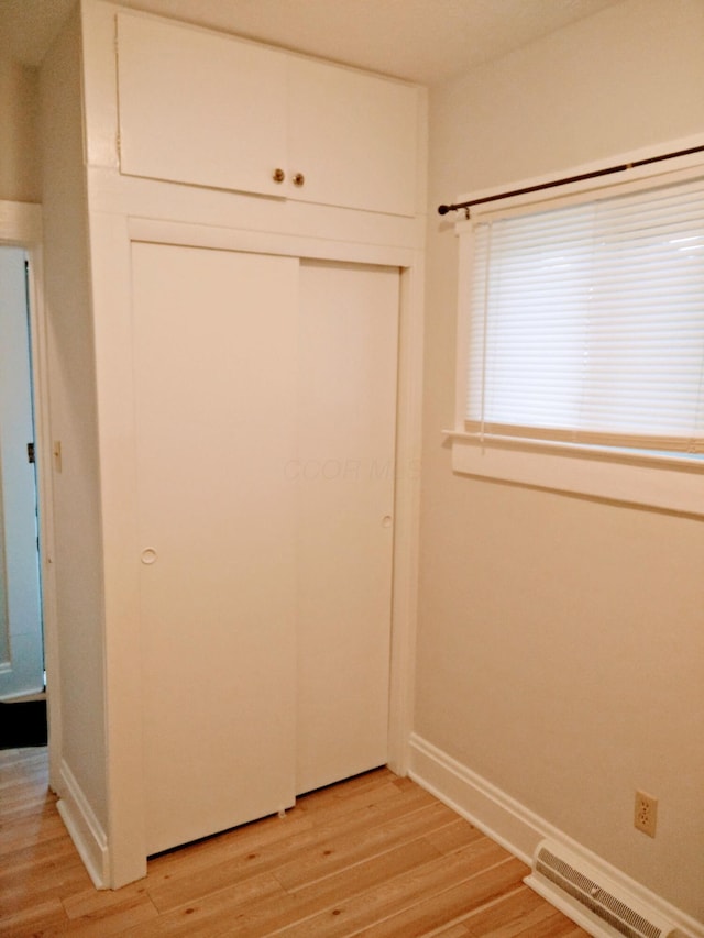 unfurnished bedroom featuring a closet and light hardwood / wood-style flooring