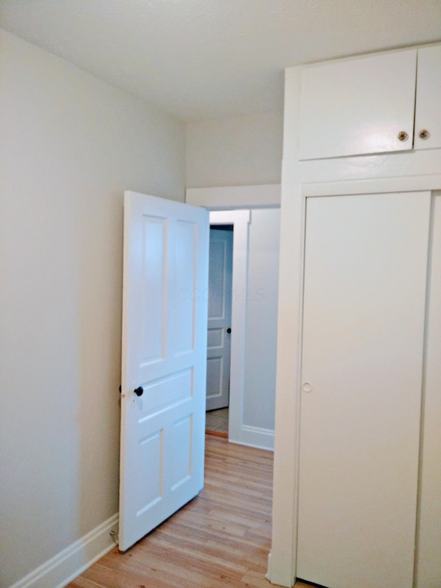 unfurnished bedroom with a closet and light hardwood / wood-style flooring