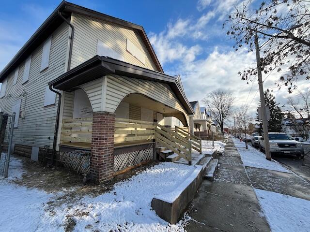 view of snowy exterior featuring a porch