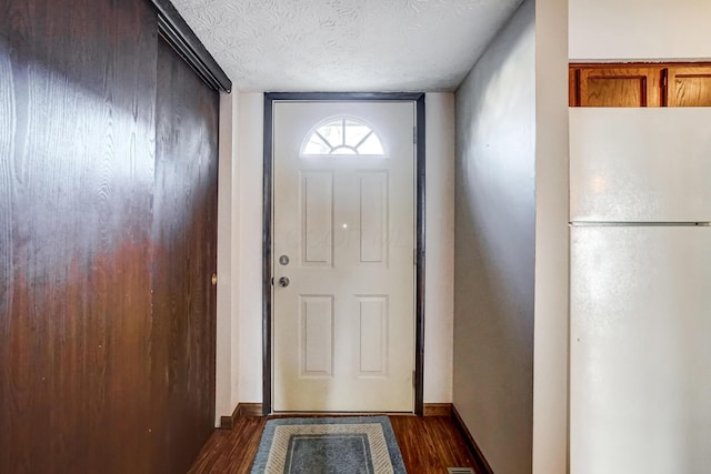 entryway with dark wood-type flooring and a textured ceiling