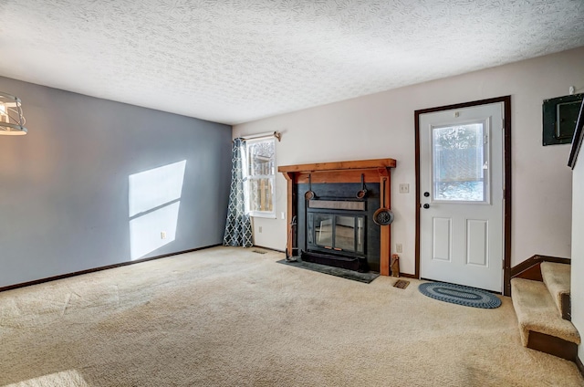 unfurnished living room featuring plenty of natural light, carpet floors, and a textured ceiling