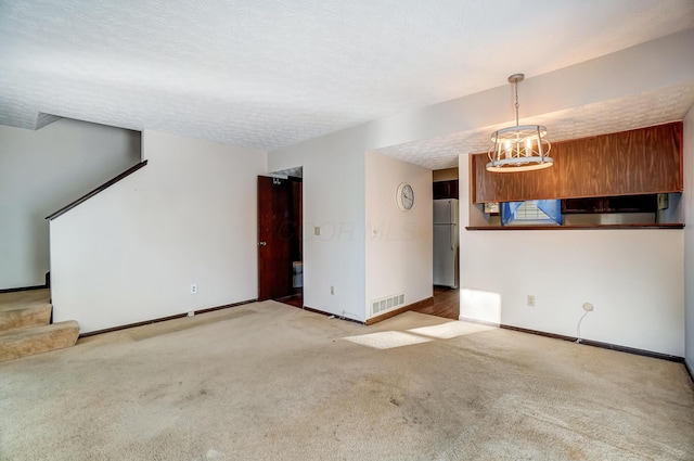 unfurnished living room with a textured ceiling and carpet