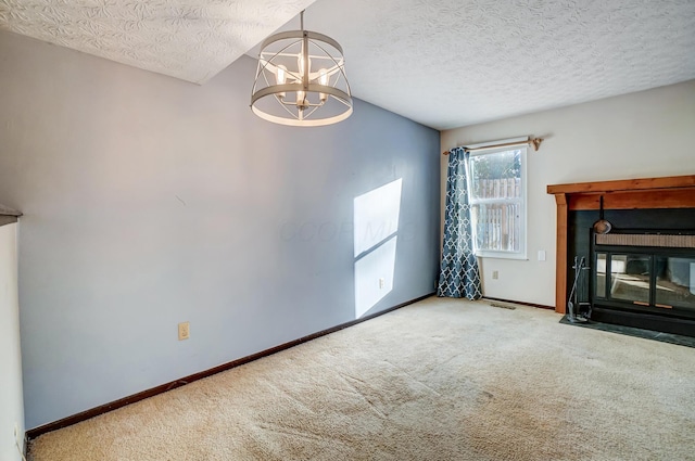 unfurnished living room with an inviting chandelier, a textured ceiling, and carpet flooring